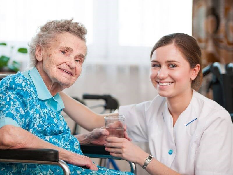 A Healthcare taker helping an Old women